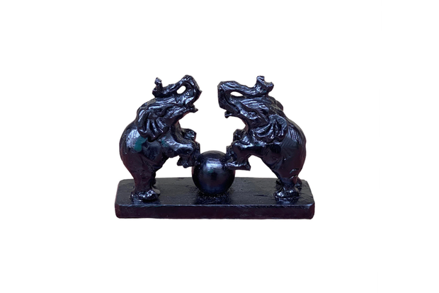 A pair of  hand-carved stone elephants stepping on ball